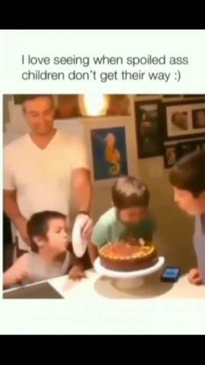 Spoiled brat tries to blow birthday candles .