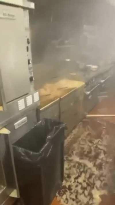 Pouring a cup of ice in a deep fryer