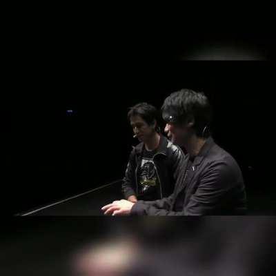 Kojima shows Geoff how to solve his puzzle.