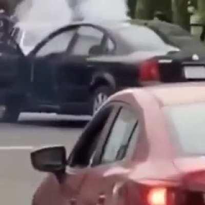 LA rioter lights firework on the street. Gets it thrown back into his car.