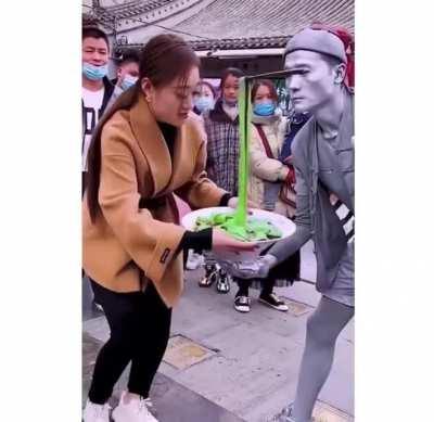 This girl giving a street artist a (probably) much needed snack