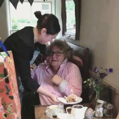 Staff surprise regular customer with a free cake on her birthday