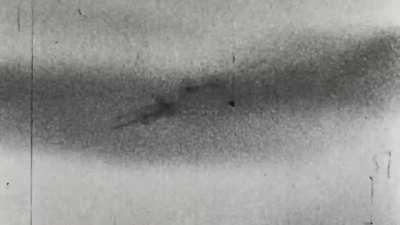 What appears to be a de Havilland Mosquito goes down under fire from a Luftwaffe fighter