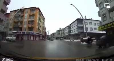 Buildings collapse around a person driving a car in Gaziantap, Turkey during the 2nd major quake