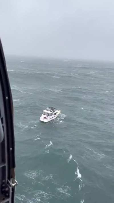 Sinking ship at the mouth of the Columbia River. Today. Coast guard rescue arrived just in time to capture footage and rescue captain.