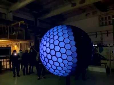 This ball by Nicholas Perillo made up of hexagon tiles, with 486 stepper motors, 86,000 LEDs and a 5 channel granular synth engine, combines the best of blinky LEDs and animatronics into one amorphic ball.