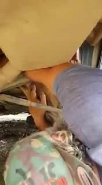 Human helps a good boy stuck under a car