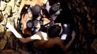 Guys jumping into a well