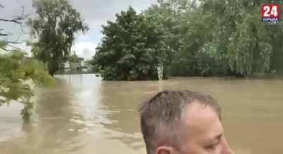 Governor of Crimea which was annexed by Russia from Ukraine is inspecting a flooded city with his bodyguards swimming behind