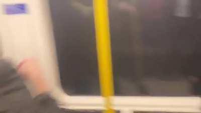 Football fan whose team just lost at home surrounded by rival football fans on the train