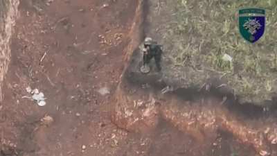 Drone footage of a Russian soldier trying to lay a mine near an anti-tank ditch, getting attacked by an FPV pilot of the Ukrainian 38th Marine Brigade, and falling into the trench himself.