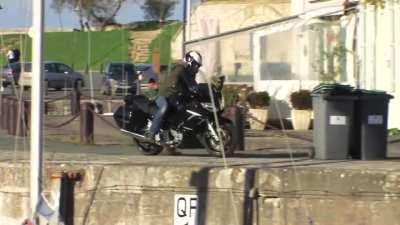 Riding a motorcycle next to the docks