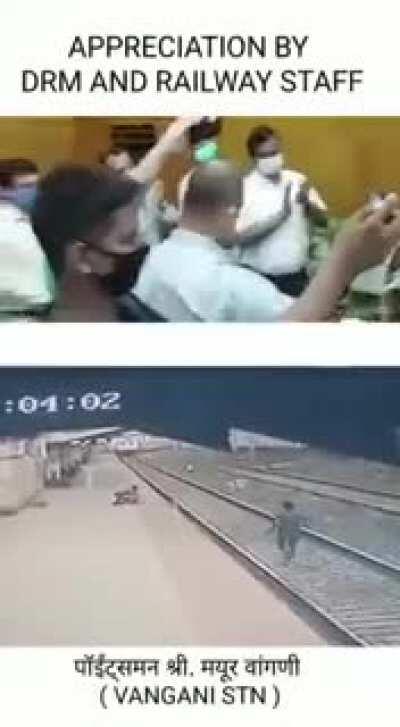 How was that person able to walk in that walkway below with those huge big balls of his is beyond me. The railway staff appreciating the person who saved a life.