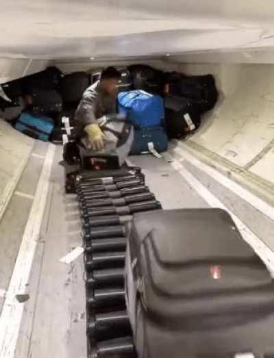 How the baggage handlers load bags on a plane.