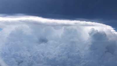 Plane flying past a storm