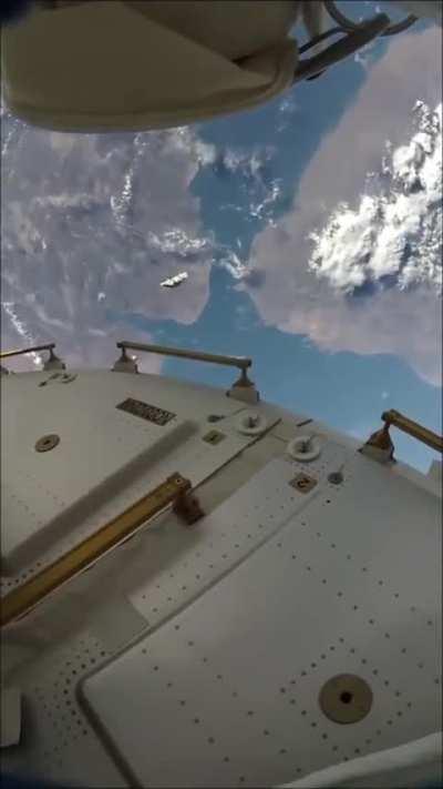 Astronauts on a spacewalk with visible space junk orbiting nearby.