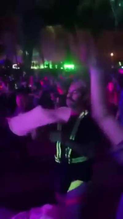 Dude flipping pizza dough at an outdoor music show