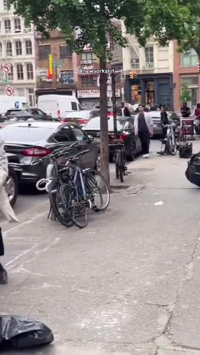 Man in a 3-piece suit and bike helmet runs around the street in NYC attacking people