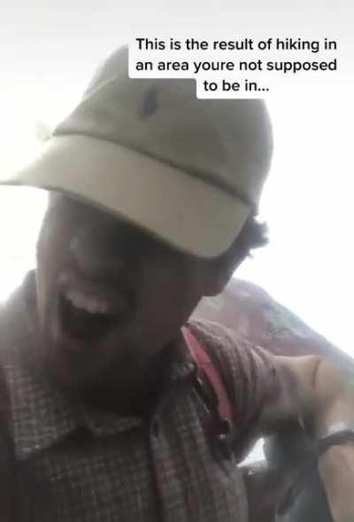 Man with his dog fully regretting hiking in an area he shouldn't have been.