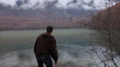 Dude enjoying himself at a frozen lake