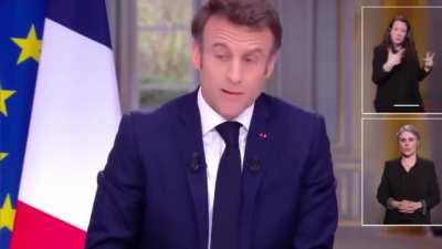 Macron is in an interview asking for sacrifices from French people but realizes he is wearing a $90,000 watchand like a magician makes it dissappear under the table