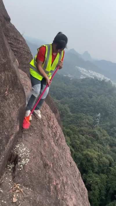 Cleaner sweeping edge of a cliff in China