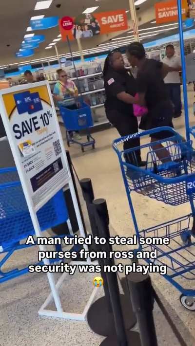 Thief struggling with shop security guard to retrieve 