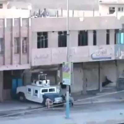 Someone throwing explosives at a Hummer from a roof top. Iraq. Undated video.