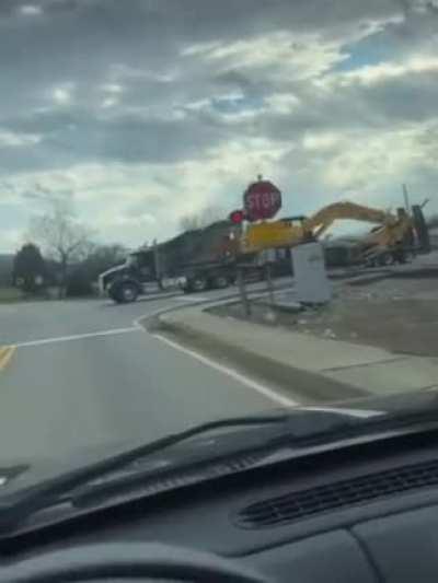 Trailer hauling an excavator gets stuck at train crossing