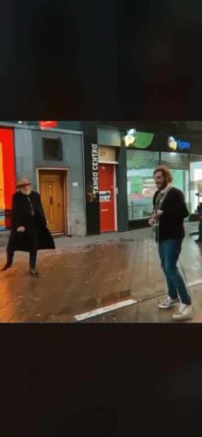 Busker provides some tunes for elderly man to groove