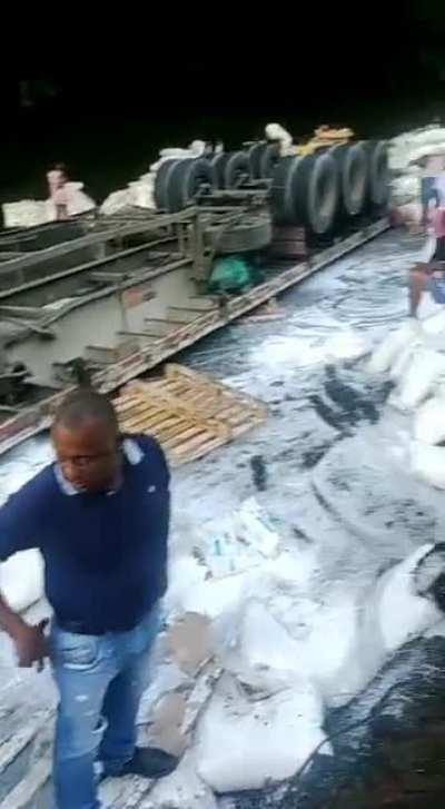 Aftermath of truck crash, people casually take the truck’s contents
