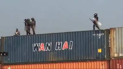 Pakistan state machinery (police/rangers) throw off a man from a 3 story high shipping container stack while he's praying