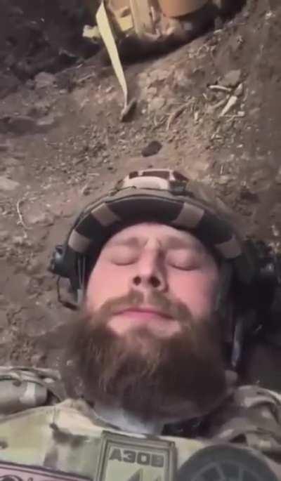 Soldier laying in a fox hole