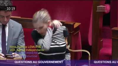 The person standing behind France’s Secretary of State for the Economy.