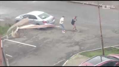 Russian woman gets taken out by flying roof panels in strong wind