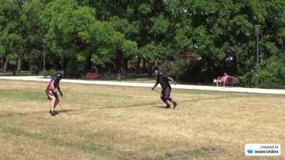 Two guys with whips sparring in the park