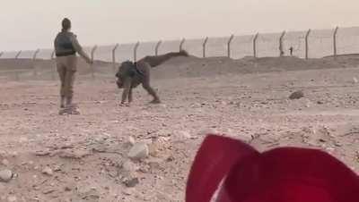 Israeli and Egyptian soldiers dance with each other over the border fence