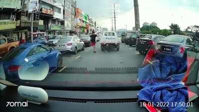 Grabbing on a vehicle while skateboarding on a busy street