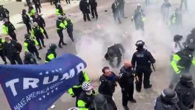 A friendly game of toss the chemical weapon canister breaks out between the insurrectionists and Police.