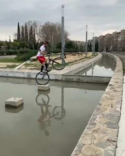 Jumping a wheelie bike across water channel