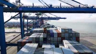 Container ship coming into port and taking on more cargo