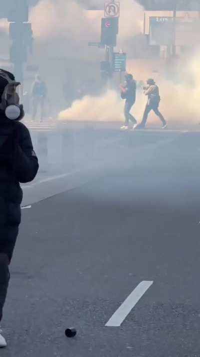 Unlawful assembly declared in Los Angels - Tear gas and rubber bullets against protestors. Woman is carried away from tear gas.
