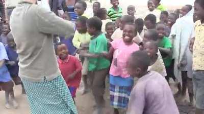 Children from an African village hearing a fiddle for the first time