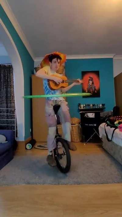 Krusty krab theme played on ukulele whilst hula hooping and riding a unicycle