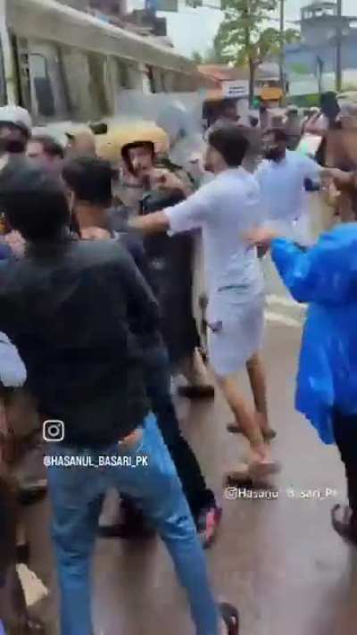 Protesters and police take some brief pause to let the ambulance pass and then resume to the clashes.