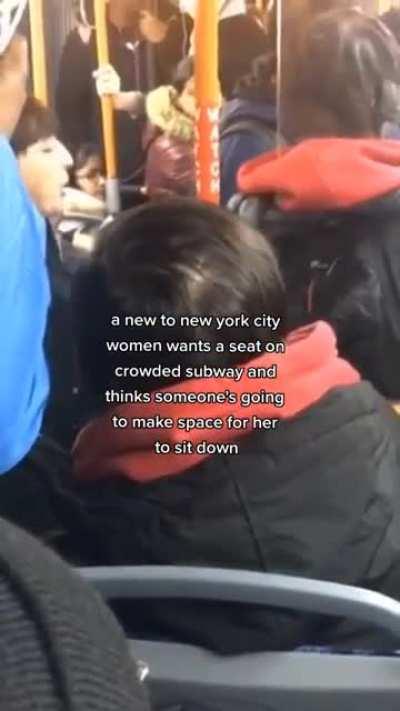 Women expects seat to be given up to her on a crowded subway