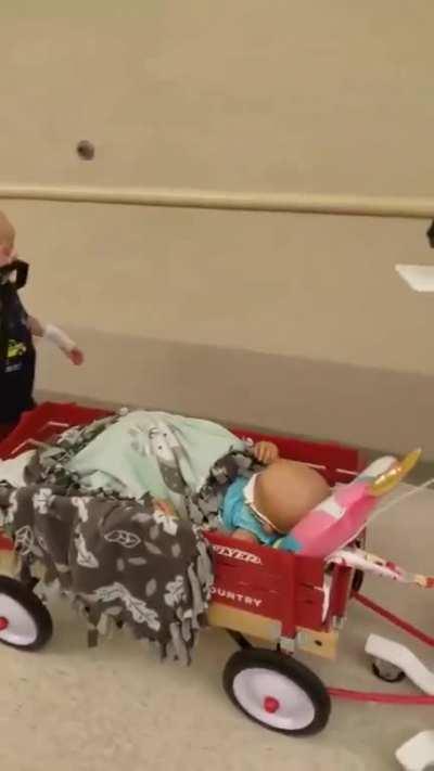 He takes his little buddy on a ride in his “Radio Flyer” wagon