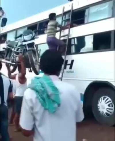 Carrying a motorcycle up a ladder like it's nothing!