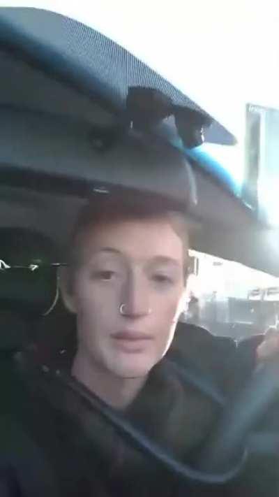 Climate activist gets confronted by an angry man after blocking off a busy road during peak hour.