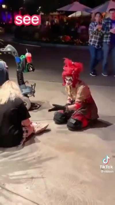 A clowns giving a nice shoe tying lesson